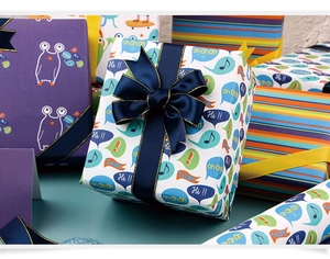 Detailed view of colorful cartoon gift wrapping paper with monsters and decorative ribbons
