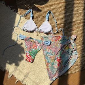 Detail of paisley print bikini set showing size S tag and matching sarong wrap beachwear