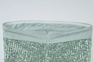 Close-up of mint green sequin skirt featuring elastic waistband and invisible back zipper