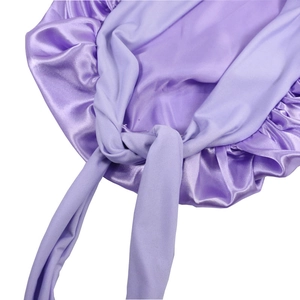 Detailed macro view of smooth purple satin bonnet with wide straps and refined pleated edges