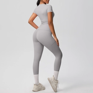 Light gray yoga set showing slimming fit and pocket detail on high waist leggings