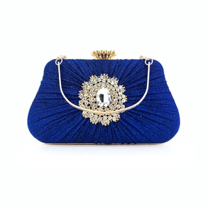 Detailed view of royal blue pleated evening bag with crystal buckle and gold handle