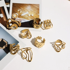 Collection of eight gold-plated minimalist rings with various geometric textures and wave designs