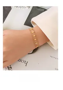 Close-up of minimalist double-layer gold chain bracelet with diamond-shaped metal accents