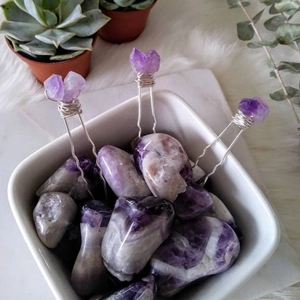Handmade amethyst crystal hair pins with silver wire wrapping on a white stone background