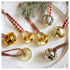 Close-up of champagne star cut-out bells with festive red plaid ribbons in a dish