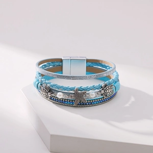 Macro detail of Bohemian multi-layer sea turtle and starfish bracelet with magnetic buckle