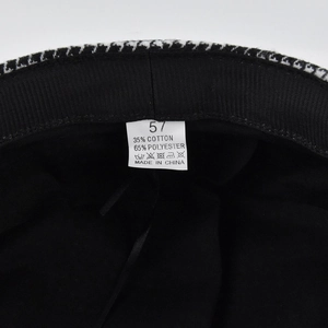 Macro shot of newsboy hat inner lining showing size 57 label and material composition