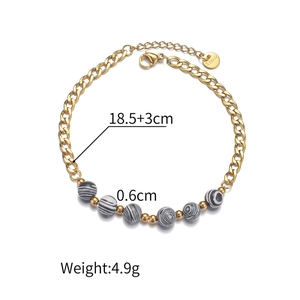 Detail of 18K gold stainless steel bracelet with striped beads and lobster clasp
