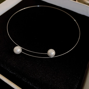 Collier ras du cou argenté élégant avec deux perles blanches dans un écrin en velours noir