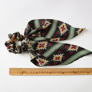 Measurement photo showing 31cm length of black satin scrunchie with floral ribbon