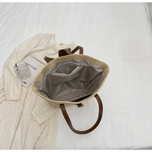 Detail view of large straw tote bag featuring interior zipper pocket and spacious lining