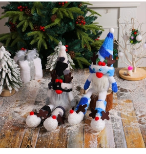 Detailed close-up of plush Christmas reindeer gnomes on wooden floor with festive decorations