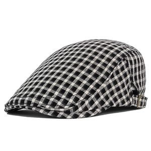 Close-up of black and white plaid pattern and metal adjustment buckle on the flat cap