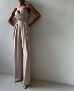Detail of elegant V-neck champagne jumpsuit showing smooth fabric texture and thin straps