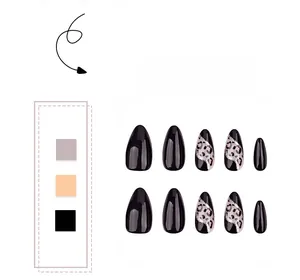 Detail of almond-shaped fake nails with leopard print, black finish and silver glitter accents
