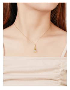 Close-up of gold 925 sterling silver drop pendant necklace with a clear zircon on neck
