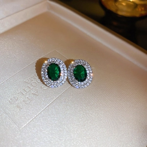 Macro shot of emerald green zircon earrings with shimmering double halo stones