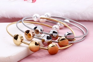 Detailed stack of stainless steel cable bracelets with pearls in gold, rose gold and silver