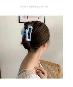 Detailansicht einer hellblauen eckigen Haarklammer zur Befestigung eines Dutt-Stylings