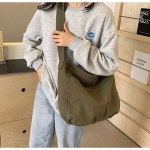 Detail of olive green canvas tote bag with wide shoulder strap and side pockets