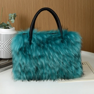 Close-up of the fluffy teal faux fur texture and black leather handle on a tote bag
