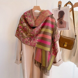Detailed texture of ethnic floral pattern pashmina shawl with fringe hanging on coat