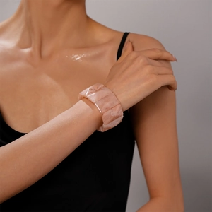 Pink marble texture resin cuff bracelet worn by a model in a black dress
