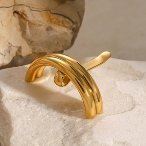 Minimalist gold U-shaped hair fork in stainless steel on white textured stone