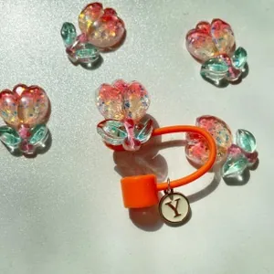Detail of pink resin tulips with glitter and a golden letter Y charm on a cord