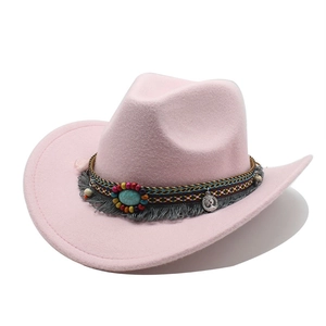 Detail of pink wool felt cowboy hat with turquoise stone and ethnic tassel band