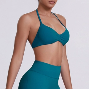 Detail of dark teal seamless ribbed sports bra with halter neck and ruching detail