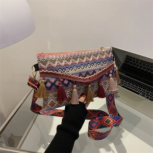 Detail of bohemian crossbody bag showing colorful woven geometric patterns and fringe tassels