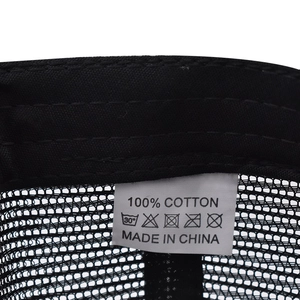 Detail of internal wash label showing 100% cotton material on black mesh baseball cap
