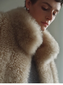 Detail of beige faux fox fur cashmere vest collar with soft luxurious texture
