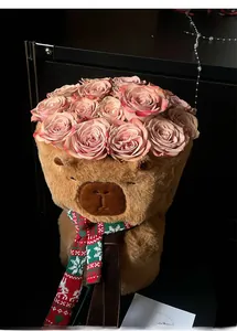 Capybara plush flower holder with pink roses and a festive Christmas knit scarf