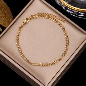 Detail view of a layered gold clover bracelet with pearls inside a luxury jewelry gift box