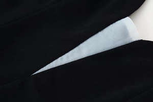 Macro shot of fine stitching and fabric texture on black dress with blue lining detail