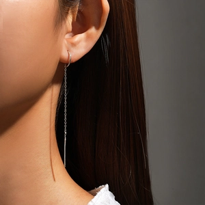 Detailed view of long S925 sterling silver chain tassel drop earrings worn by a model