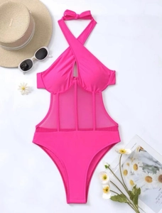 Flat lay of fuchsia halter swimsuit featuring mesh paneling and summer accessories