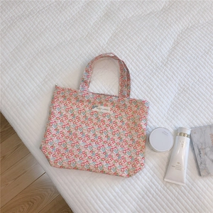 Détail du sac cabas en coton à fleurs avec motifs floraux rouges et bleus sur fond doux