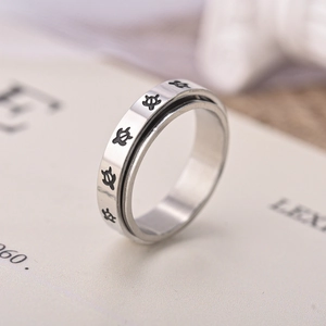Macro shot of silver titanium spinner ring featuring black sea turtle engravings