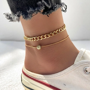 Detail of gold layered anklet set with cuban link chain and beaded snake chain