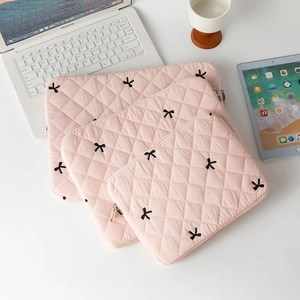 Pink quilted laptop sleeves in three sizes with black embroidered bow patterns