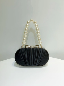 Detailansicht der schwarzen Satin-Abendtasche mit Perlengriff und goldenem Verschluss