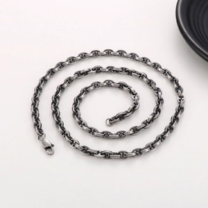 Detailed view of the 18K gold plated pig nose chain links and buckle on a grey background