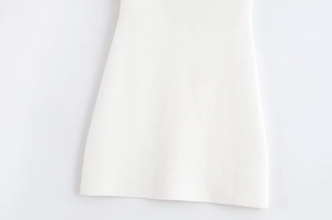 Vue détaillée de la texture de maille fine et de l'ourlet de cette robe en maille blanche