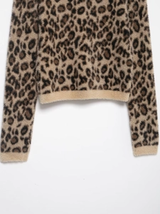 Close-up of leopard print faux fur knit fabric showing texture and cuff detail