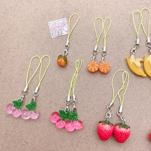 Detail of colorful resin fruit charms like cherry and strawberry with metal clasps