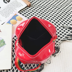 Detail of red patent leather crossbody bag with rainbow strap and white contrast stitching